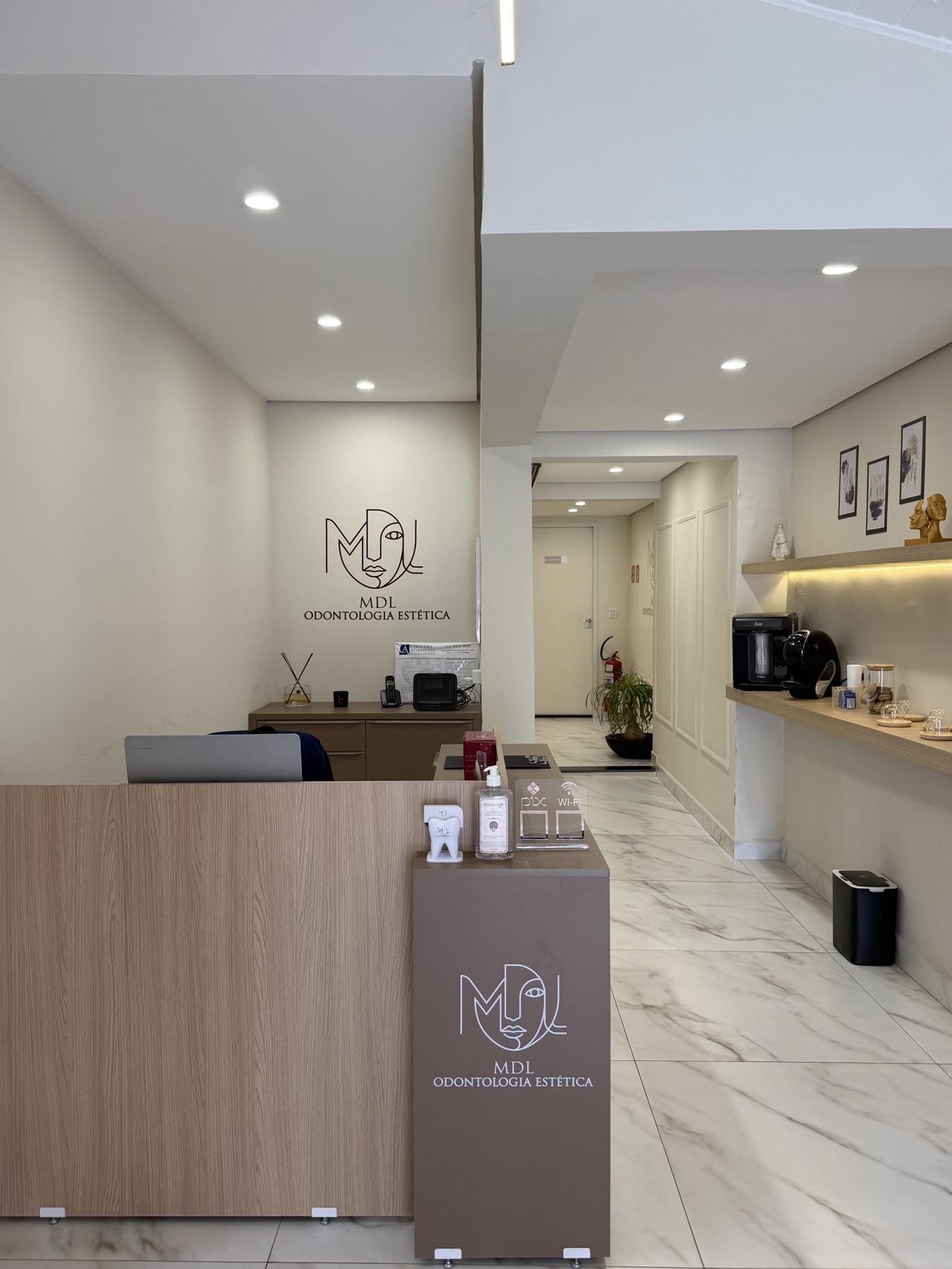 Recepção da clínica MDL Odontologia em Atibaia com balcão de mármore e logo